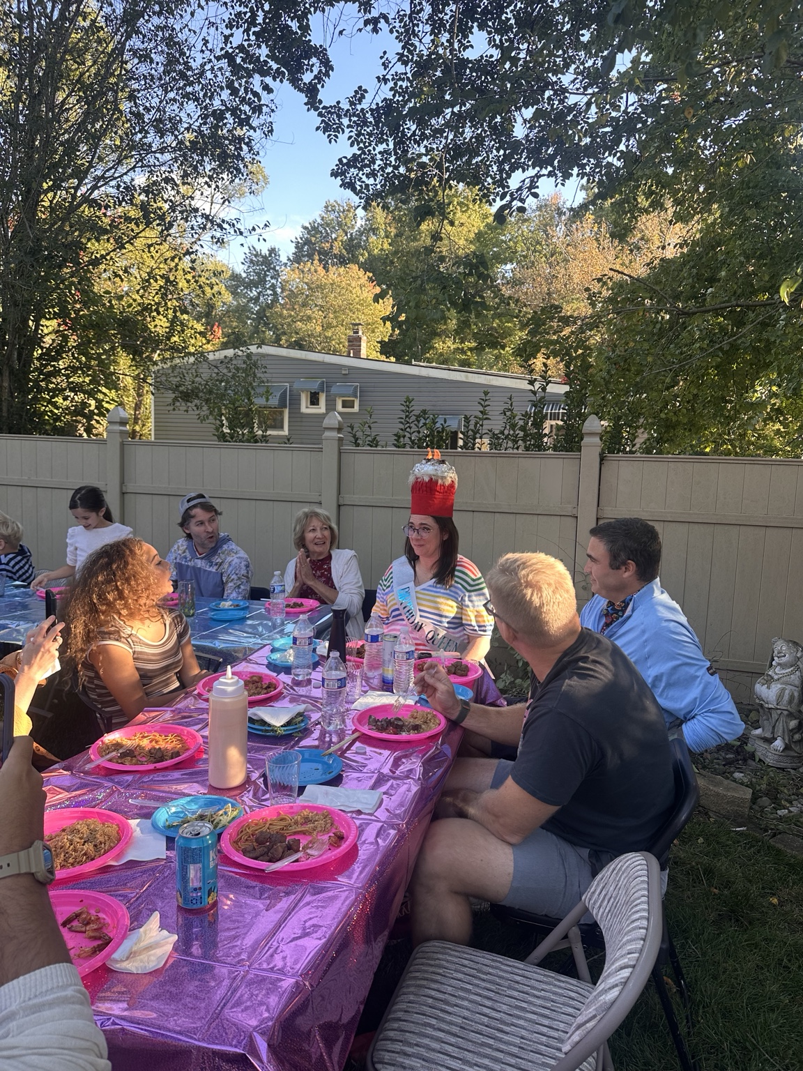 Backyard hibachi party with guests seated around the grill