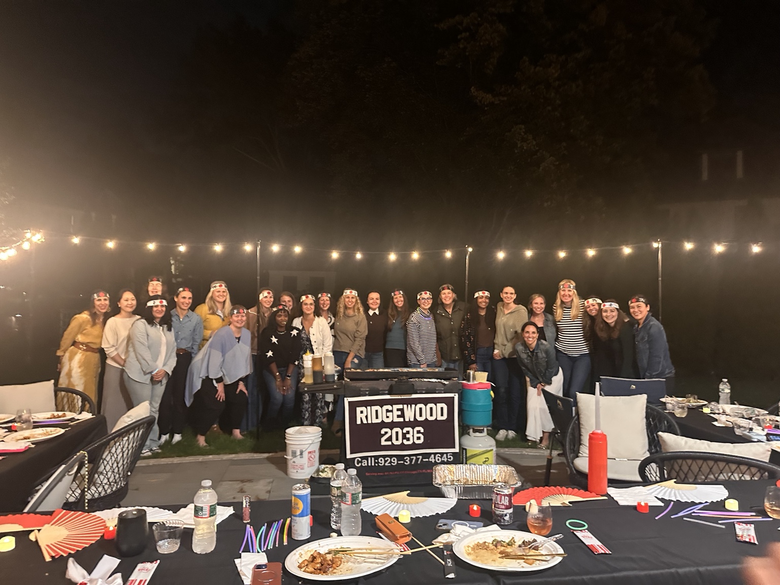 Private backyard hibachi party with guests gathered around the grill