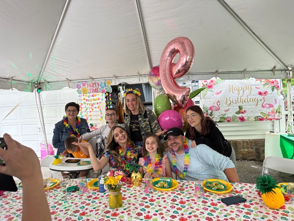 Family celebrating a birthday at a decorated outdoor dining table